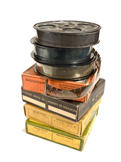 A stack of 16mm film reels and storage boxes.