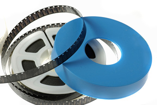 A Super8 Film reel with white holder and blue reel cover.